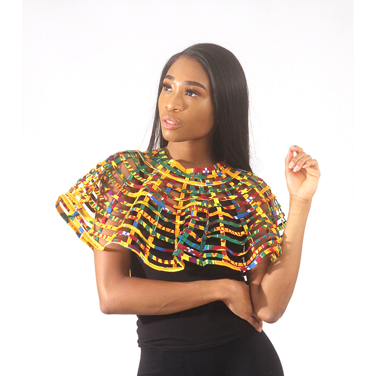  Kente Print Capette Add some eye-catching color to any ensemble with this Kente Print Capette. The capette is a short cape made with strips of material in a lattice design. It fastens at the throat. This rainbow colored capette has a traditional Kente design. It is 12” in length. Made in Ghana. C-A538 Model Miriam is 5’10" 33-26-37